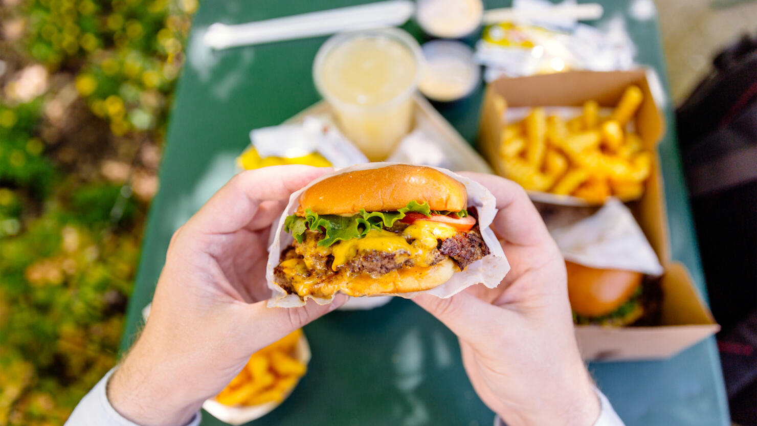 Man eating cheeseburger, personal perspective view