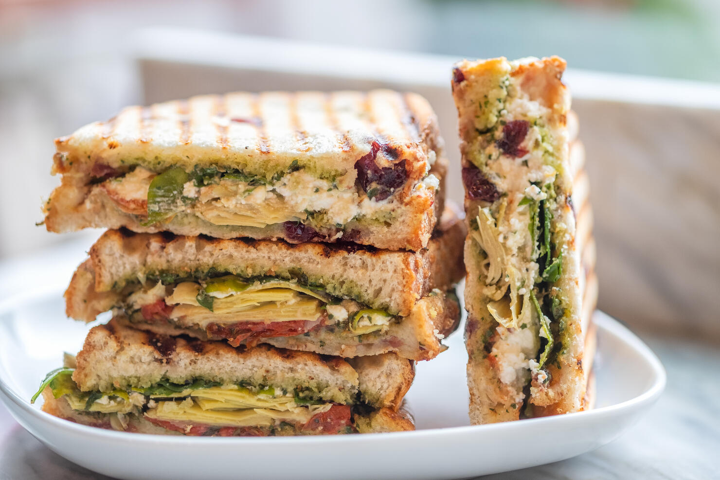 Stacked Vegetarian Sandwiches of Arugula, Artichoke, Sun Dried Tomato, Pesto