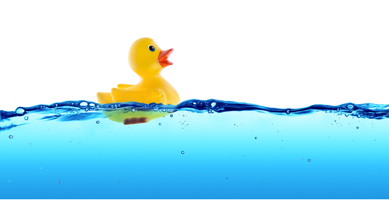 Rubber duck swimming in blue water - positive concept