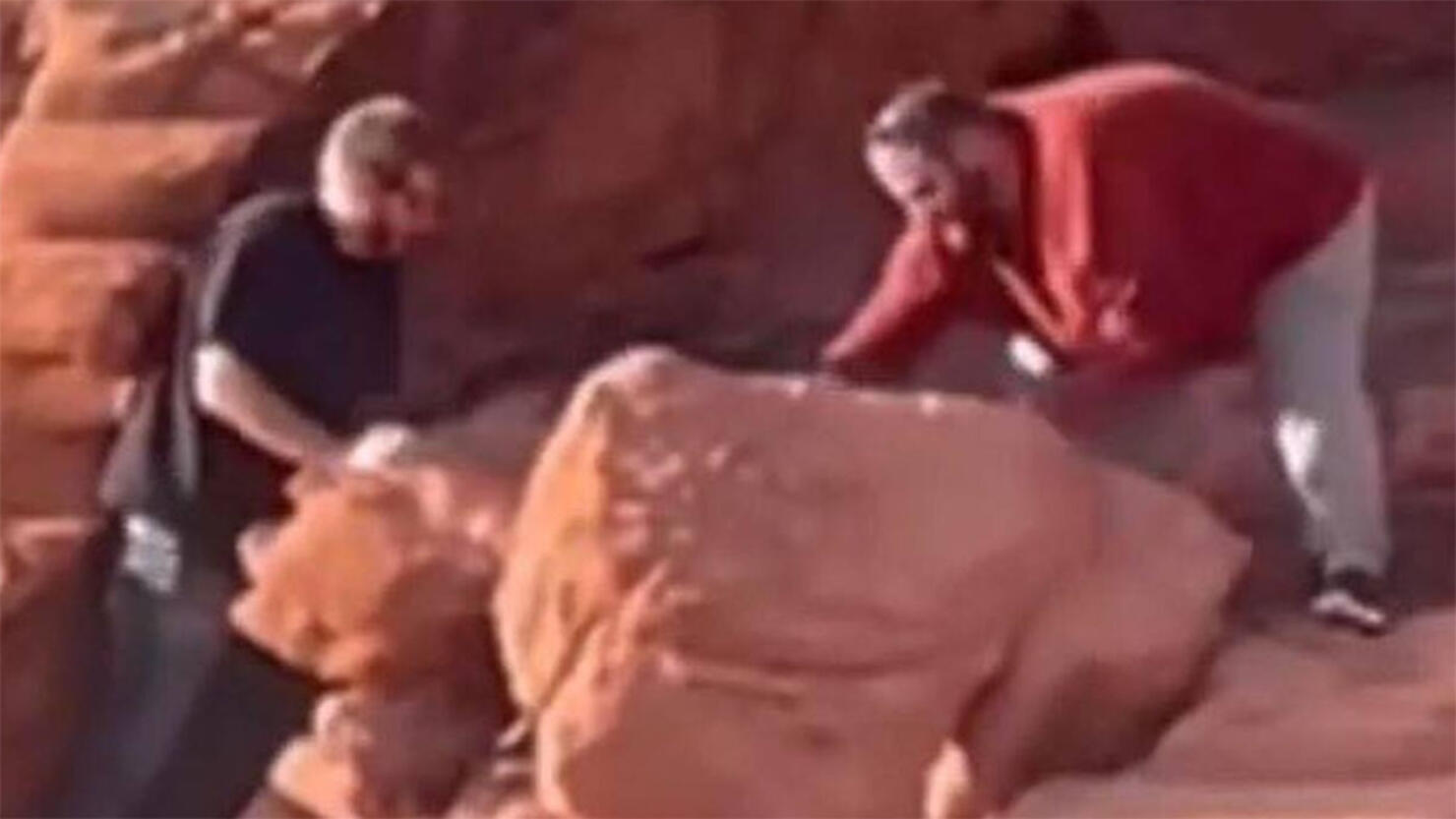 Two men topple ancient rock formations