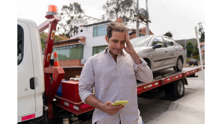 Man having problems with his car and calling roadside assistance