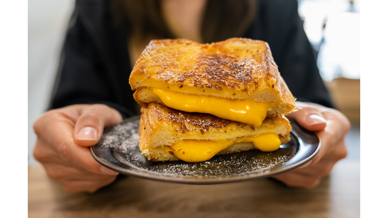 Someone holding a Cheese Toast before eating.