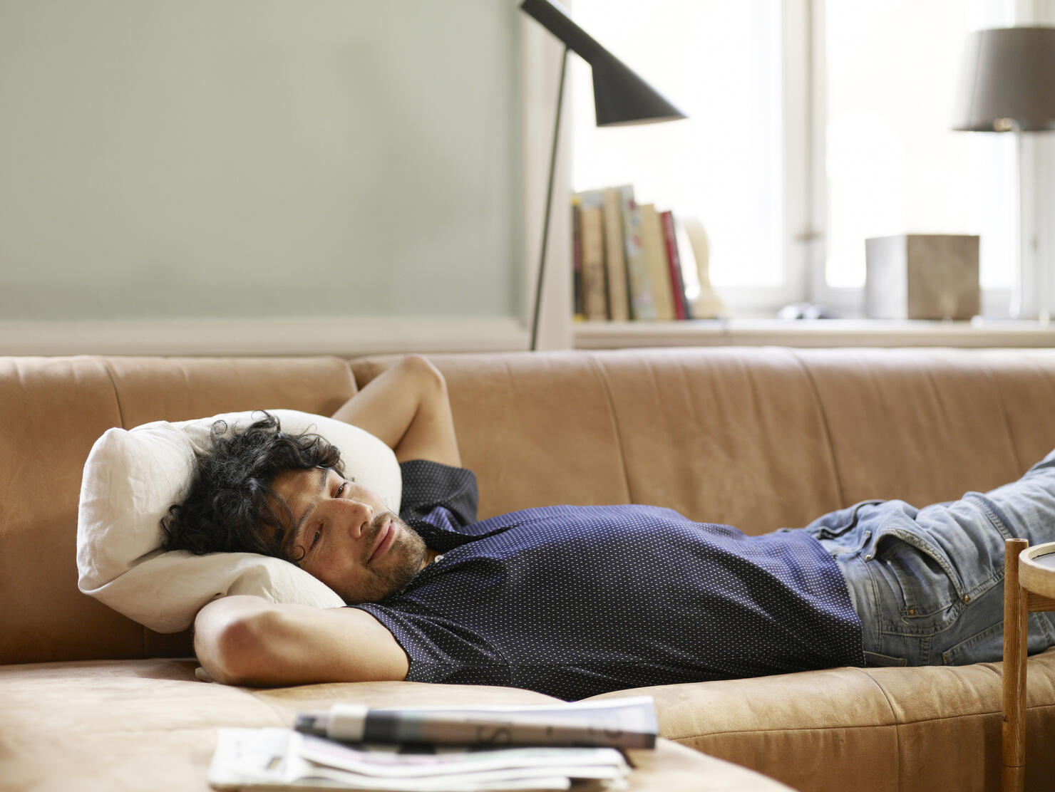 Young man lying on sofa watching TV