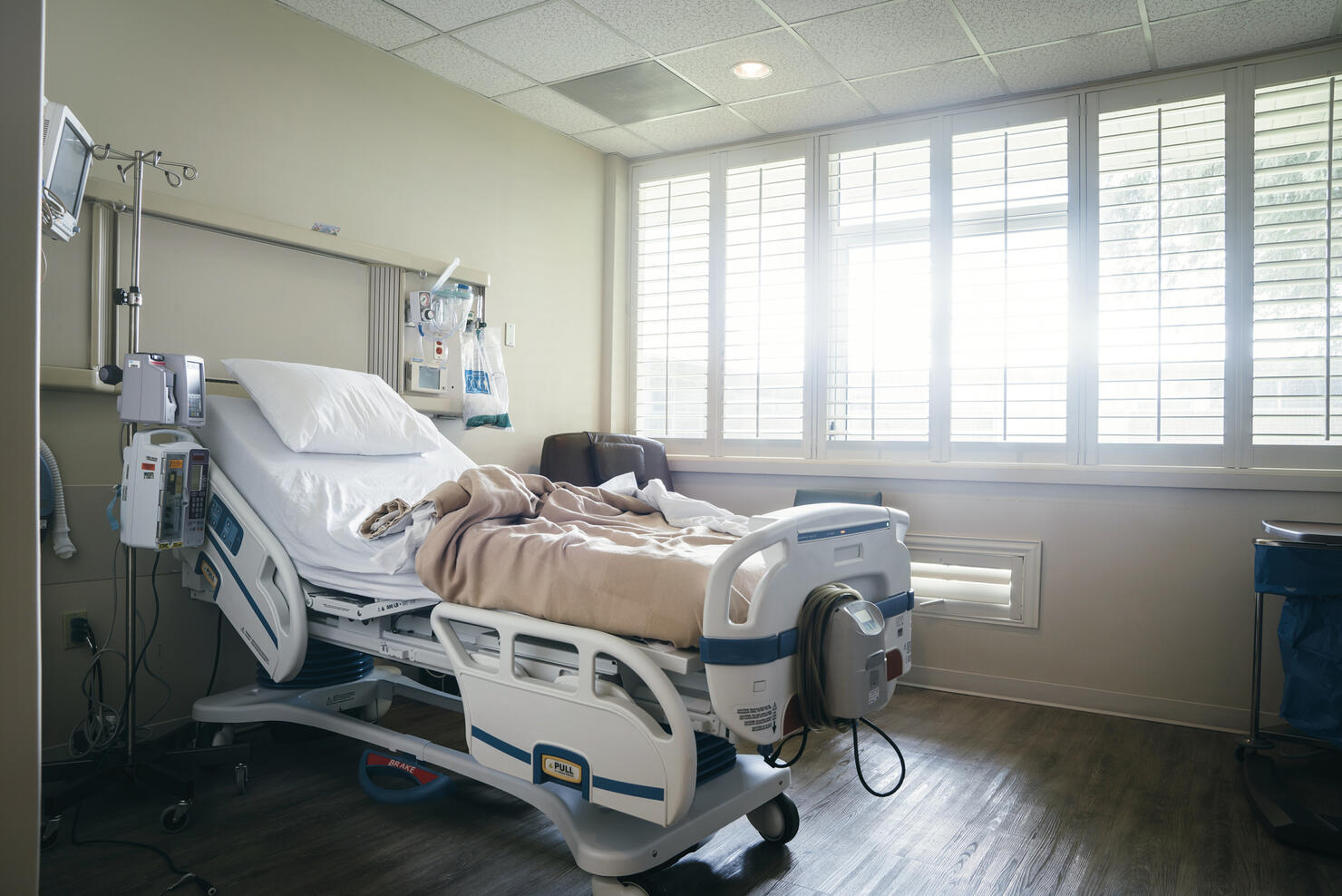 Empty hospital bed near sunny window