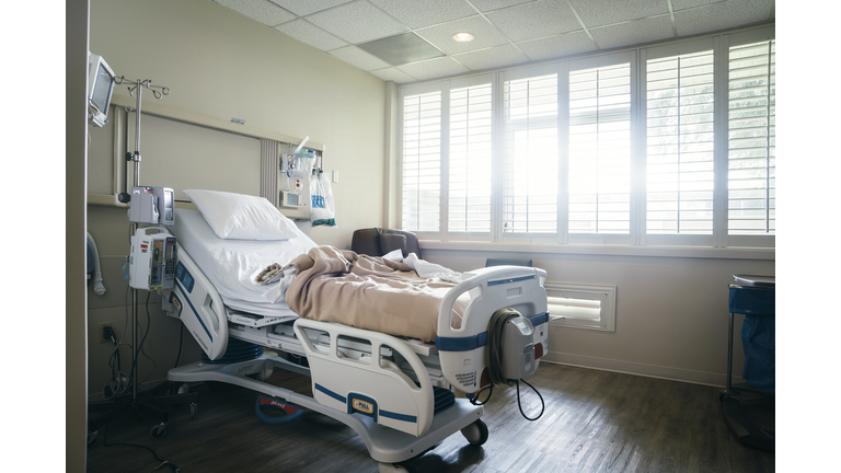 Empty hospital bed near sunny window