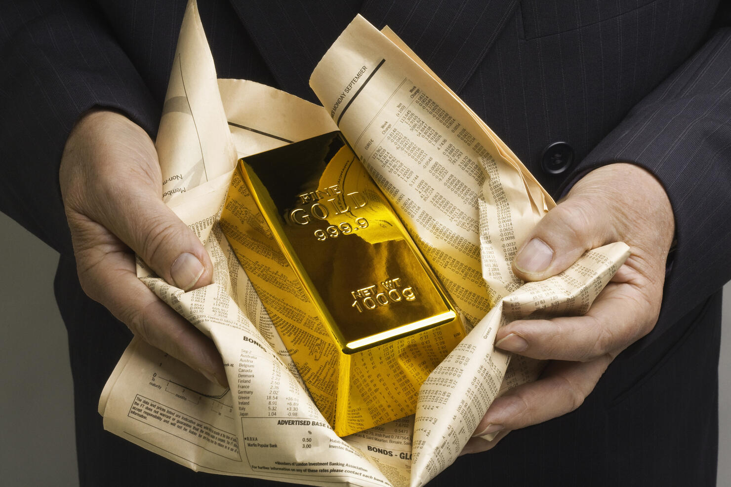 Gold bar wrapped in a financial newspaper