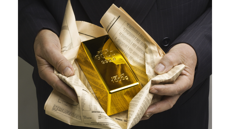 Gold bar wrapped in a financial newspaper