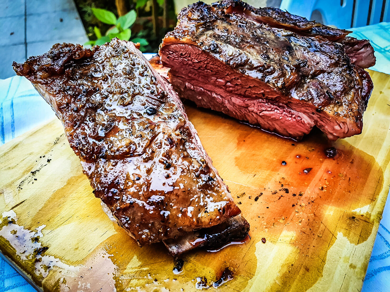 Close-up of argentine grilled ribs (asado argentino or costillar) on a wooden board