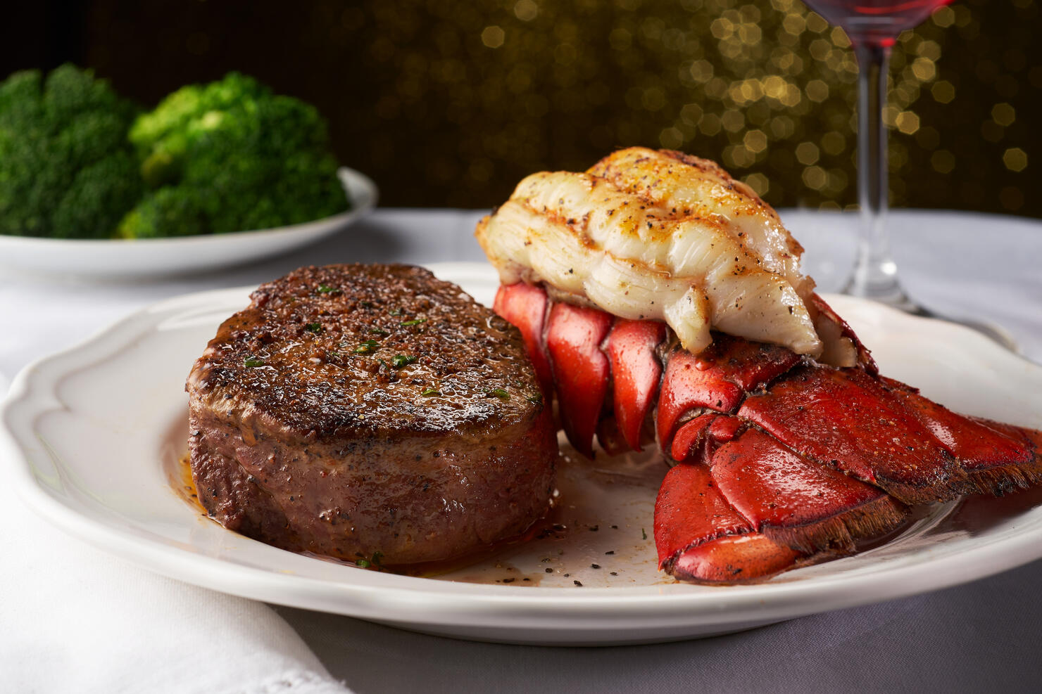 Steak and Lobster on a White Plate and Table Cloth