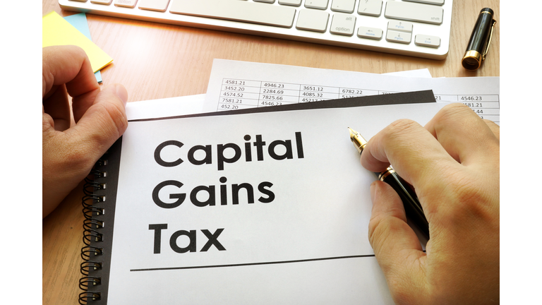 Hands holding documents with title capital gains tax CGT.