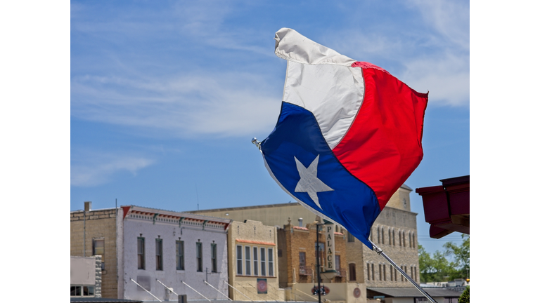 The Texas state flag flies over downtown Main street Fredericksburg Texas