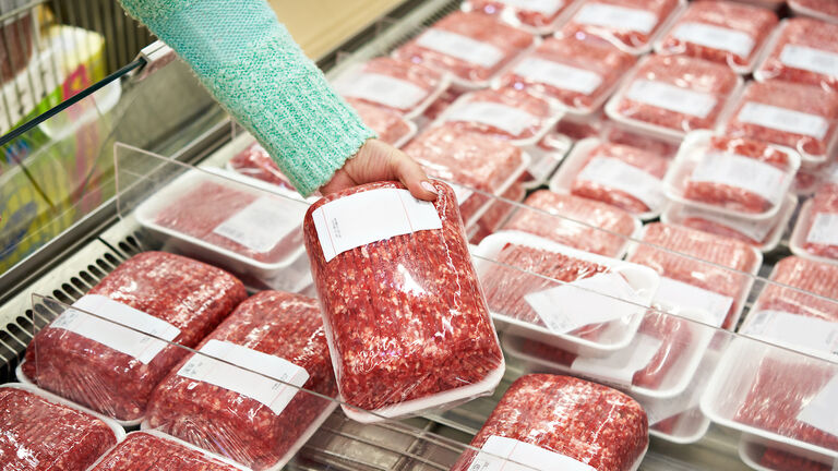 Buyer woman chooses chopped meat in shop