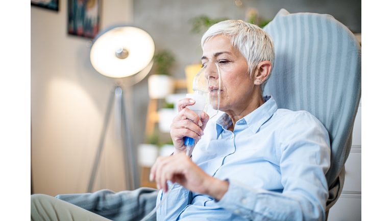 Senior woman doing inhalation.