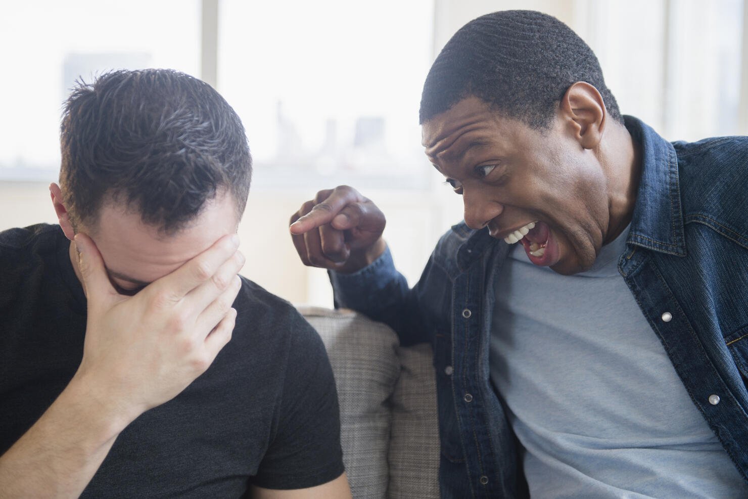 Close up of man teasing friend on sofa