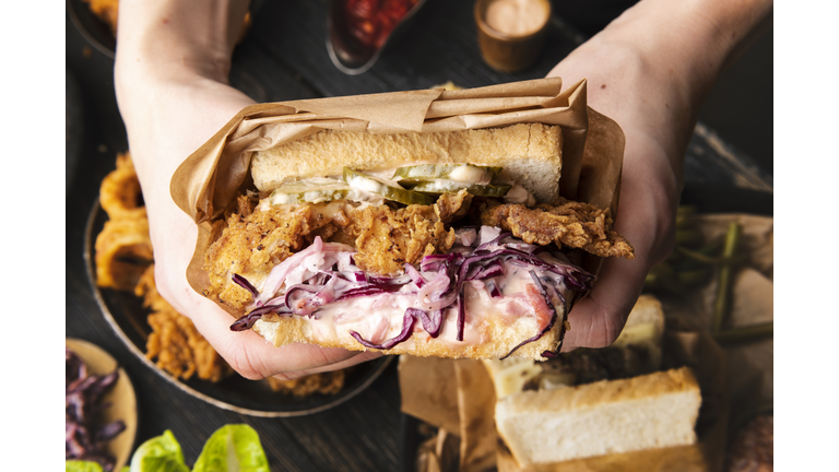 Woman is holding tasty sandwich before eating