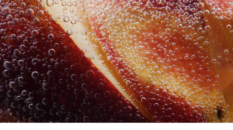 Sliced fresh peach in soda water. Extreme close-up