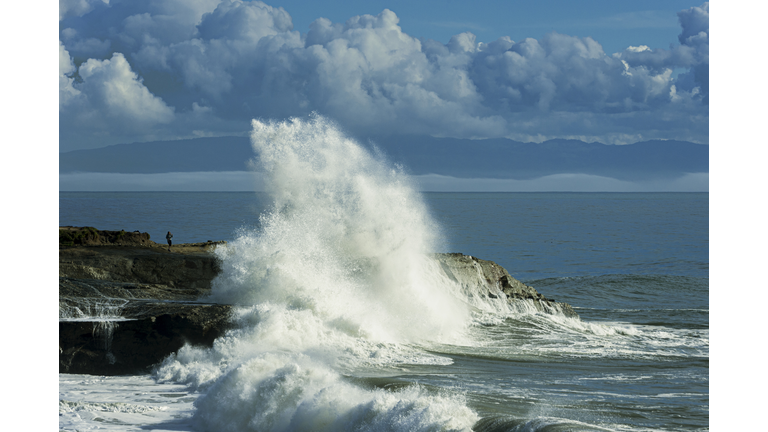 Larger Ocean Wave Crashing On Rocky Shore