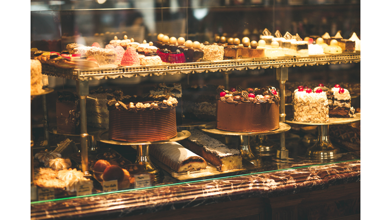 Pastry shop display window with variety of cakes