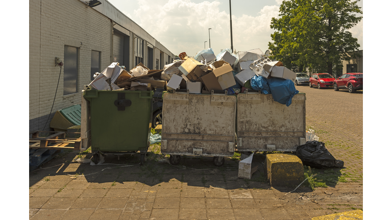 three waste containers filled to the brim with rubbish