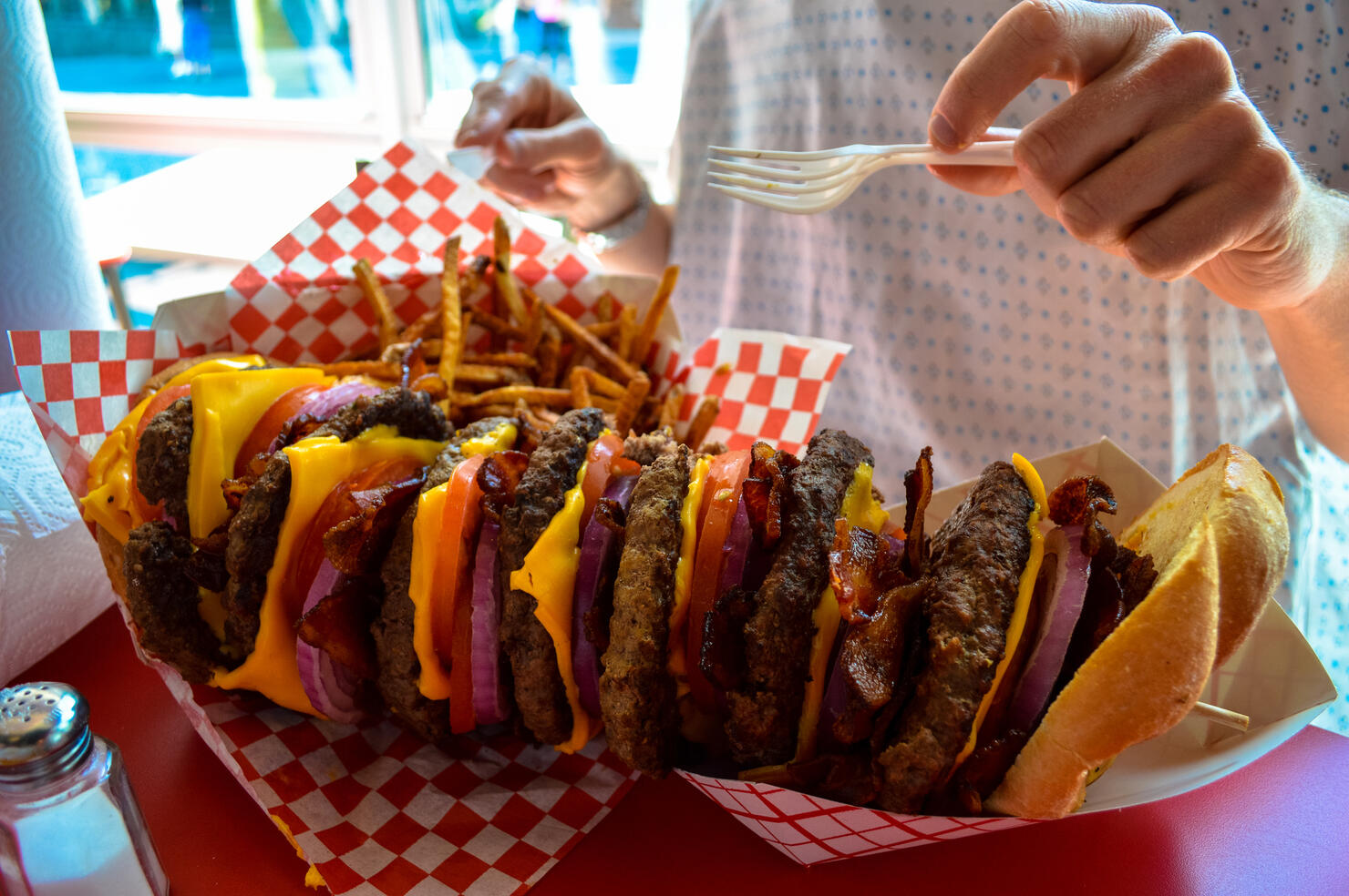 A huge stacked burger and fries
