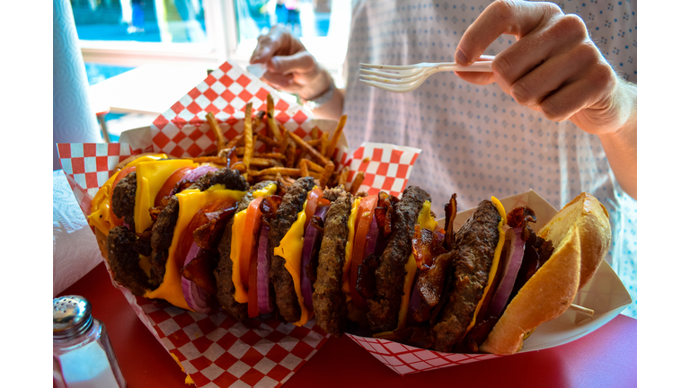 A huge stacked burger and fries