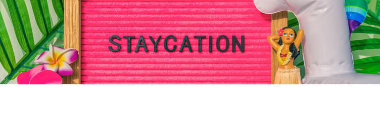 Staycation banner sign for summer vacation plans during COVID-19. Funny pink felt board text for staying home for the holidays. What to do this summer without traveling