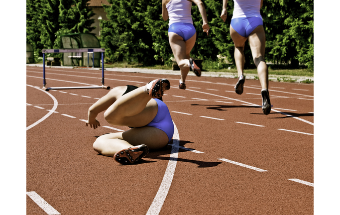 Female athlete falling down on track race