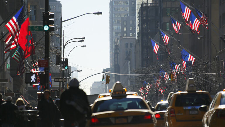 Crowded 5th Avenue traffic and American flags