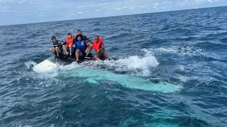 Five men stranded atop a boat