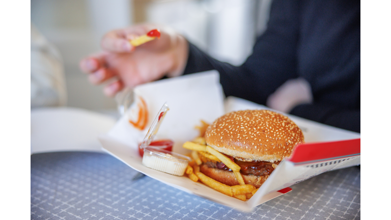 Burger and fries with dips on cardboard box delivered at home
