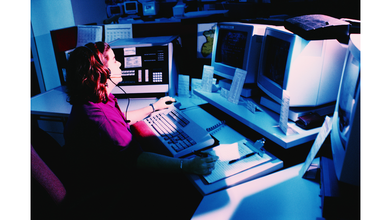 Woman working at police dispatch terminal