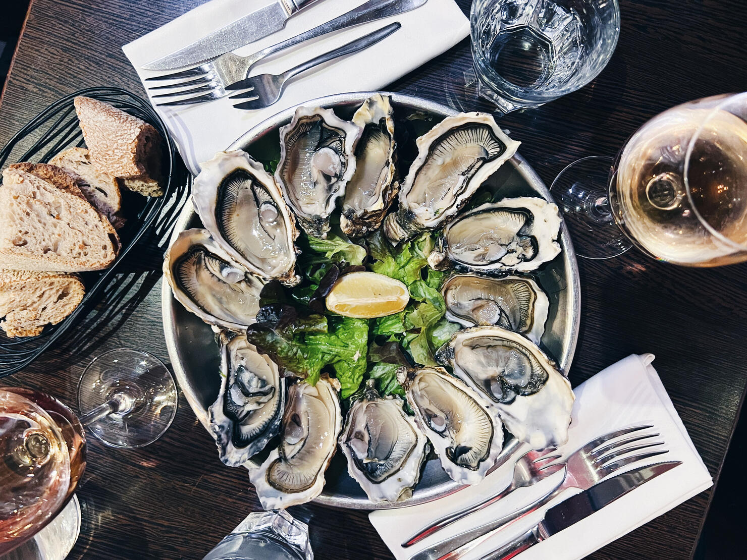Oysters plate and white wine in a restaurant, directly above view