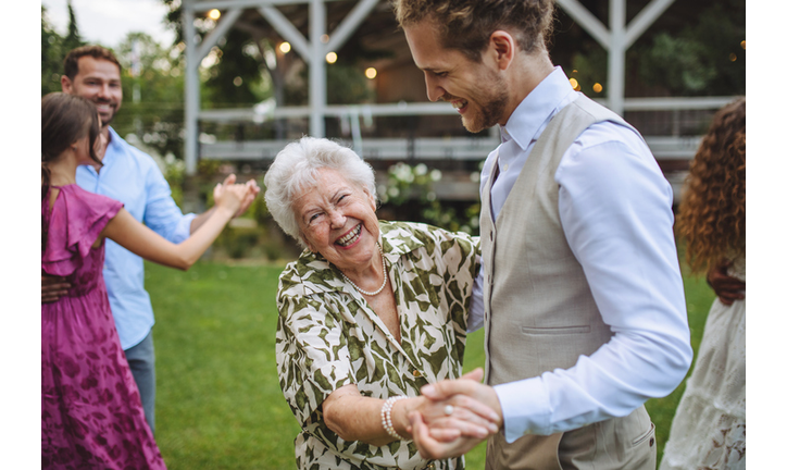 Groom dancing with his grandmother at small garden wedding.