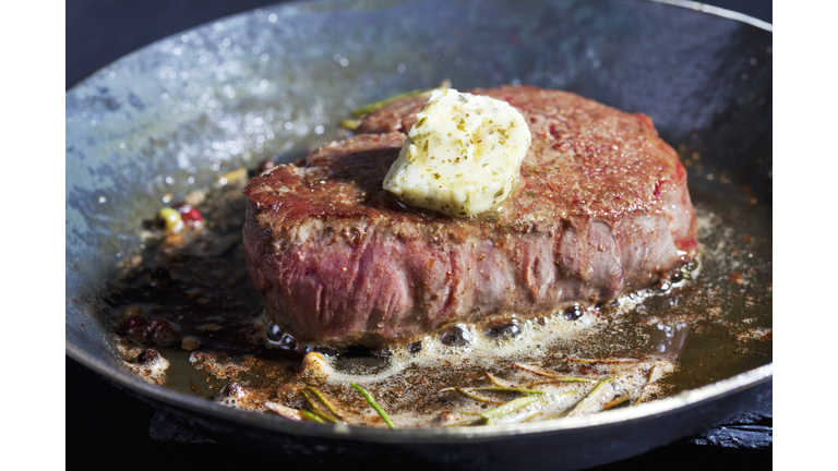 Fried fillet of beef with herb butter, peppercorns and rosemary in a pan