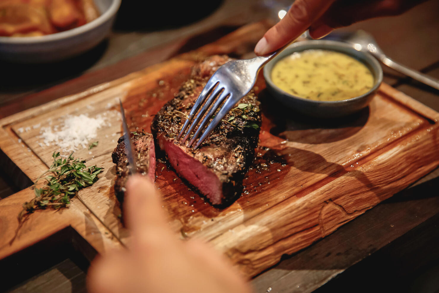 Unrecognizable Woman Eating Steak in High End Restaurant