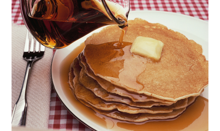 Pouring Maple Syrup on Plate of Pancakes