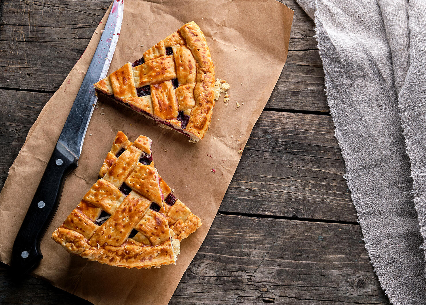 Baked cakes with a cherry and a kitchen knife are on brown paper,Romania