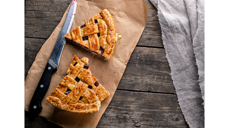 Baked cakes with a cherry and a kitchen knife are on brown paper,Romania