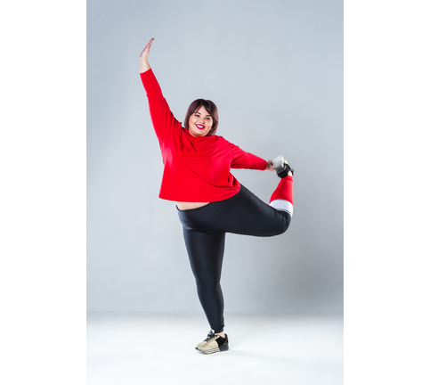 Plus size model in sportswear, fat woman doing workout on gray background, healthy lifestyle concept