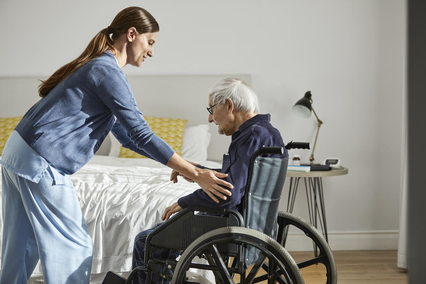 Caregiver assisting senior man on wheelchair