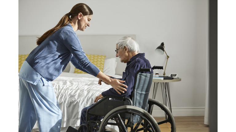 Caregiver assisting senior man on wheelchair