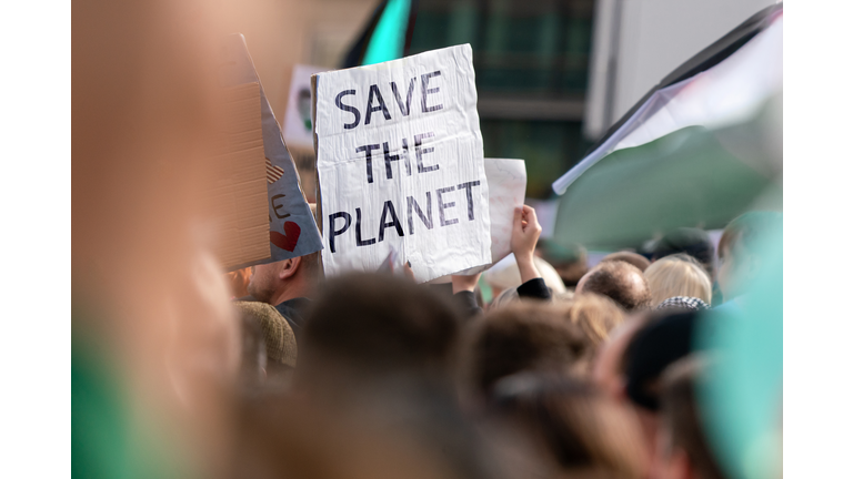 Massive protests and banner with the message SAVE THE PLANET