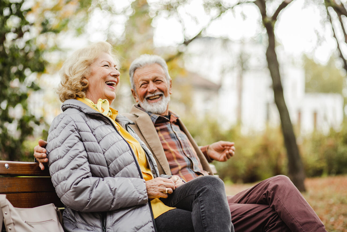 Happy senior couple sitting on the bench in park