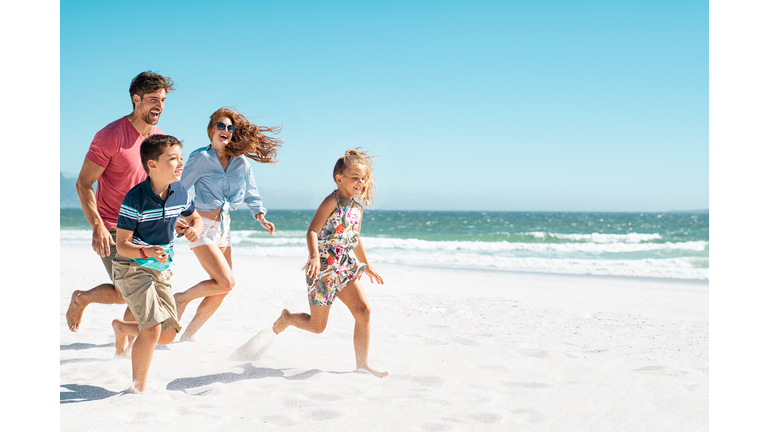 Happy family running on beach