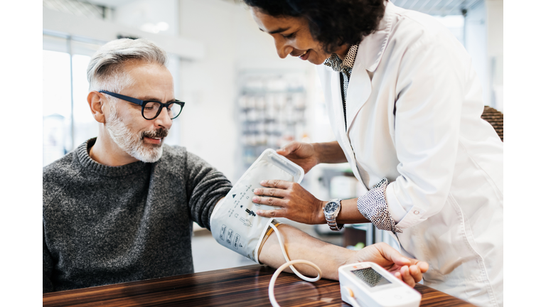 Pharmacist Measuring Mature Man's Blood Pressure