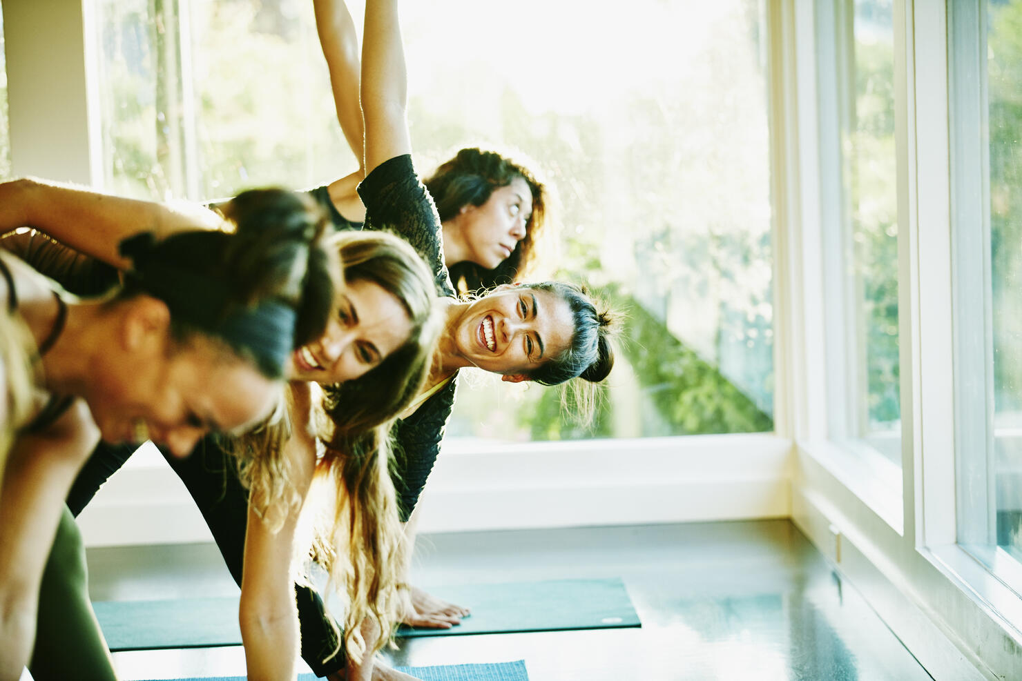 Woman laughing with friends during yoga class