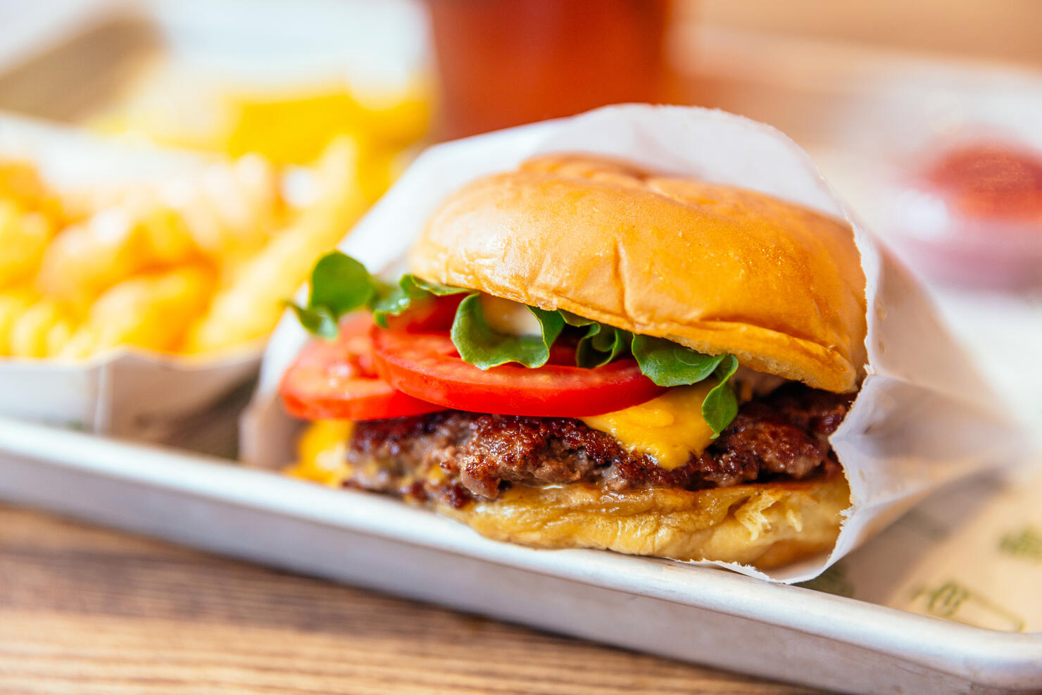 Close up of juicy cheeseburger with fresh tomatoes