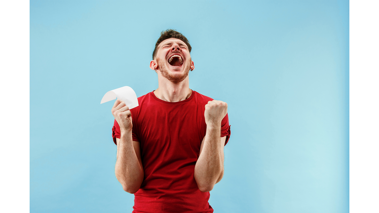 Young boy with a surprised expression bet slip on blue background