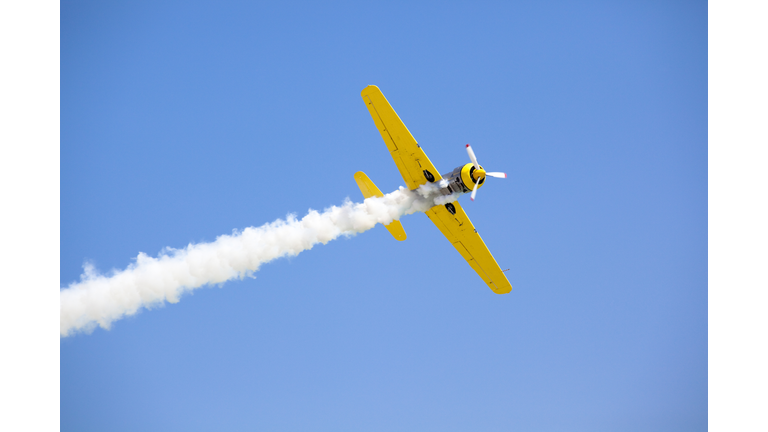 Old fashioned bright yellow propeller plane in sky