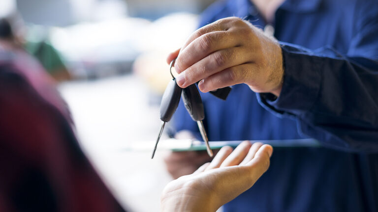 Car repairman giving car keys to customer
